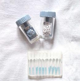 2 Kontaktlinsenbehälter und Zahnreinigungsstiks