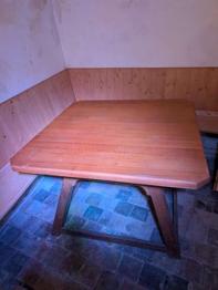 Sitzecke mit Tisch aus massivem Holz und mit Leder gepolsterter Bank